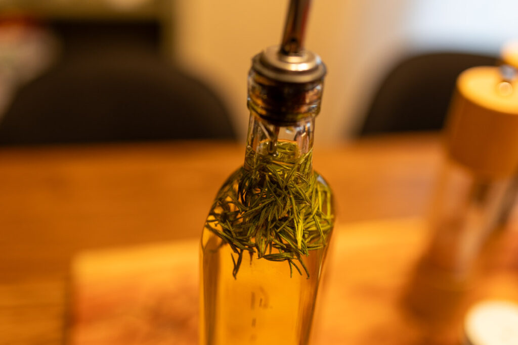 up close shot of rosemary in the jar of olive oil