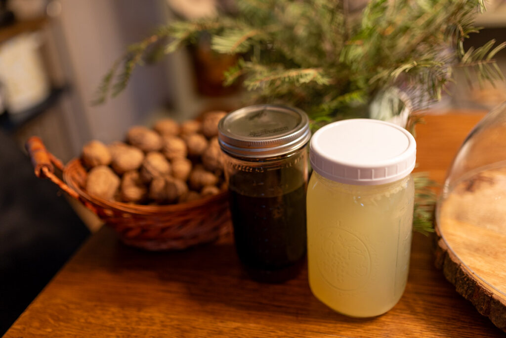 broth and elderberry syrup in jars on a table near other christmas decor