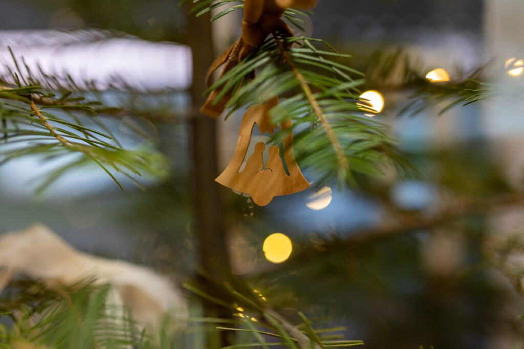 an ornament of a wooden bell with Mary and Joseph figures in it