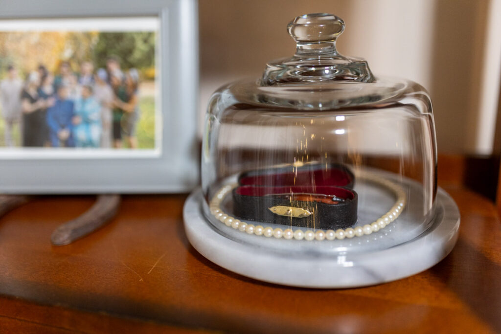 a little violin and white pearls in a glass dome