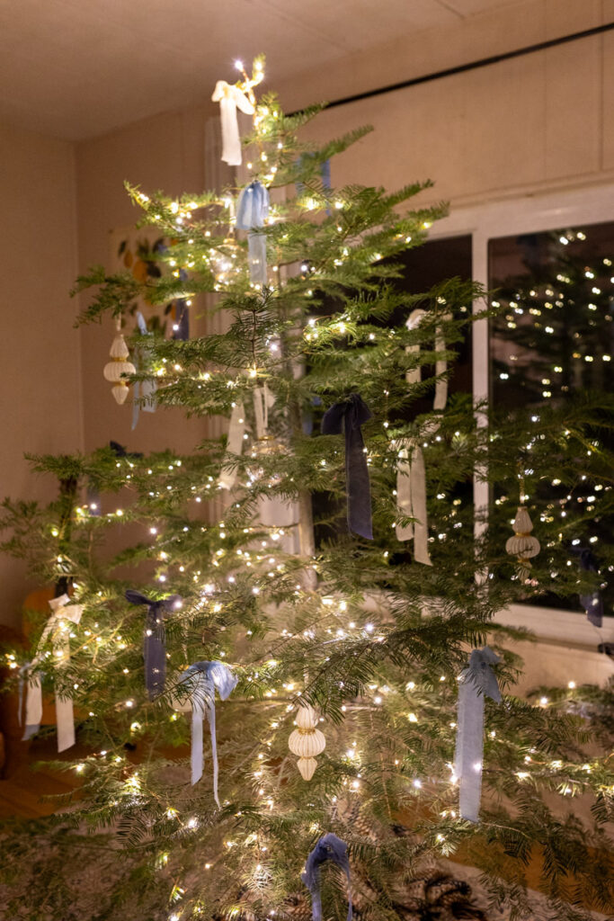 christmas tree with blue and white ribbons and ornaments