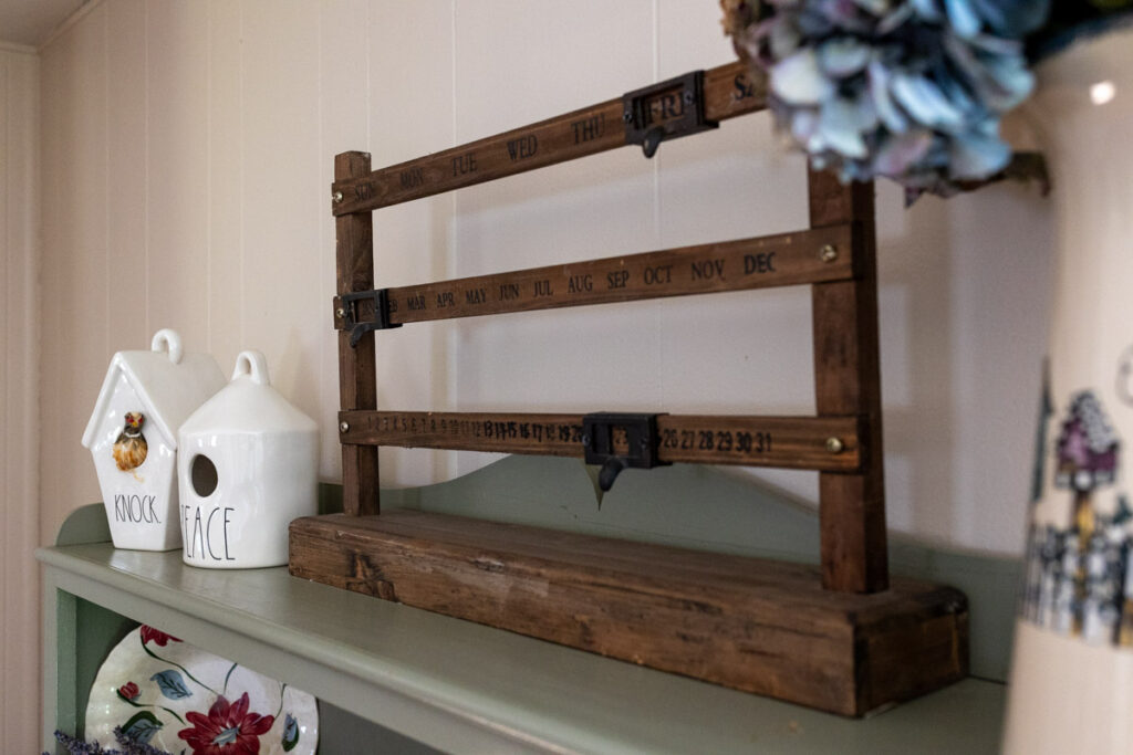 wooden calendar and two white decorative bird houses