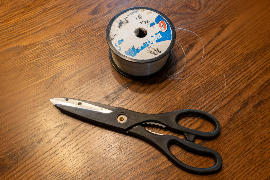 scissors and fishing wire set on a table for a project