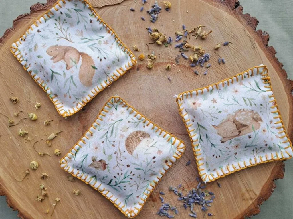 herbal sachets made out of print with woodland animals on a piece of wood and dried lavender and chamomile 
