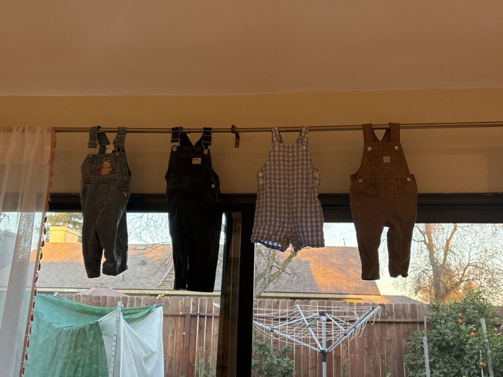 All the baby boy outfits hung on the curtain rod.